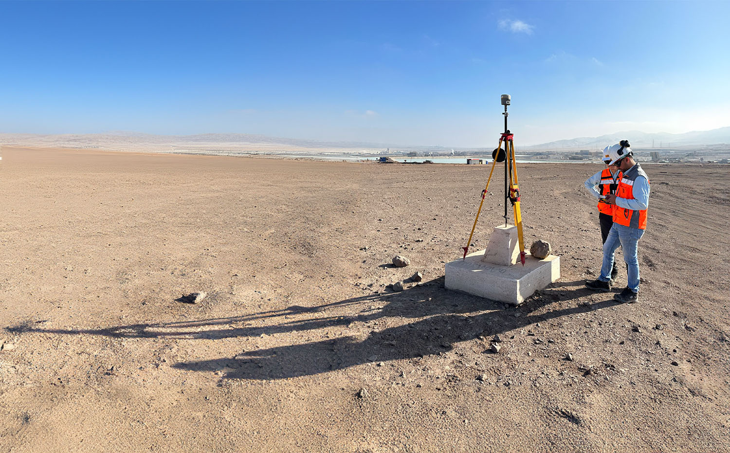 Foto de dos trabajadores de GMT instalando una base GPS